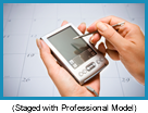 Hand using PDA with a calendar in the background (staged with a professional model).