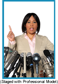 African-American woman speaking before a bank of microphones. (Staged with a Professional Model).