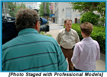 Camerman and woman interviewing a man on the street (staged with professional models).